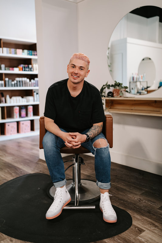 Tyler Caragata sitting in hair salon chair
