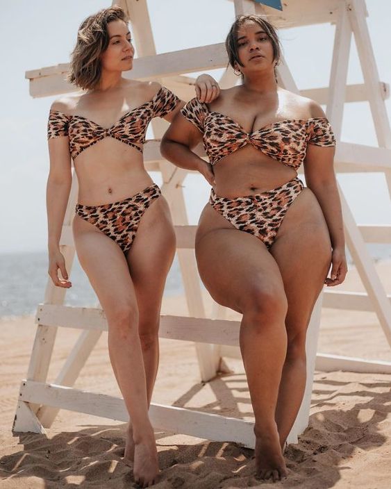 Tanned women on the beach wearing animal print bikinis