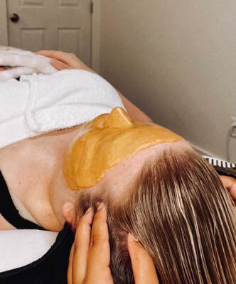 Salon Society client recieves a head massage during the jelly mask portion of a custom facial service
